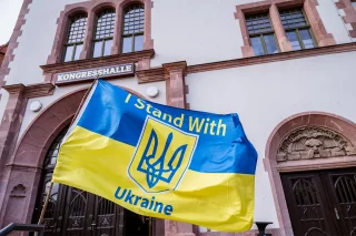 Eine Ukraineflagge mit der englischen Aufschrift "I stand with Ukraine" weht vor der Leipziger Kongresshalle.